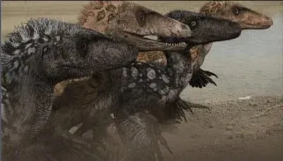 Still from Dinosaur Revolution showing a pack of feathered raptor dinosaurs charging across a beach